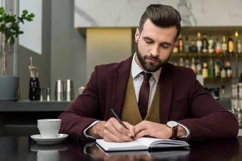 image of man writing in journal