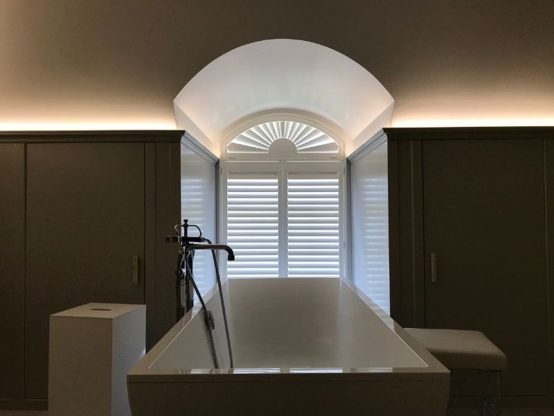 modern bathroom with dark walls and window with custom shape shutters