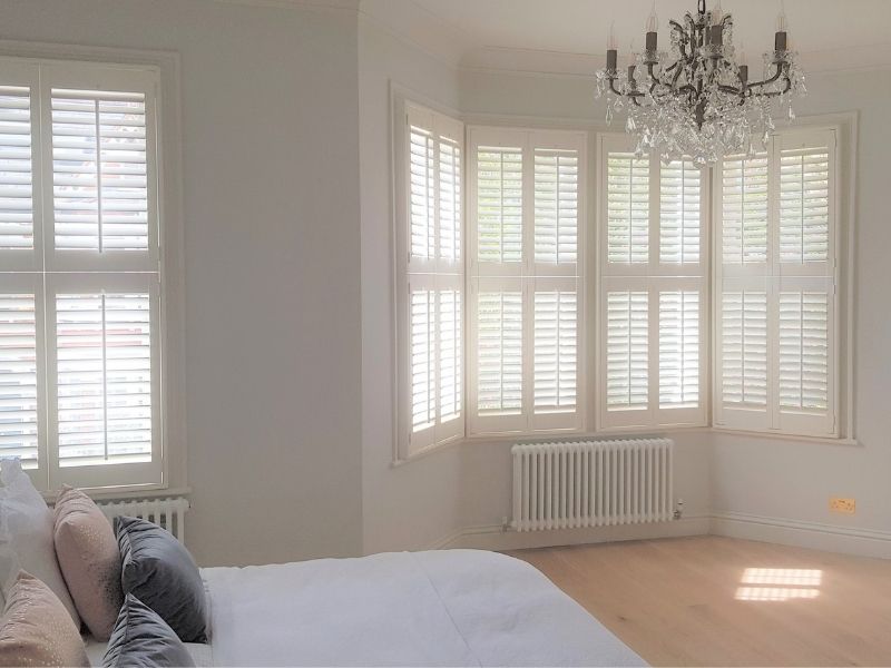 bedroom with quality bay window shutters