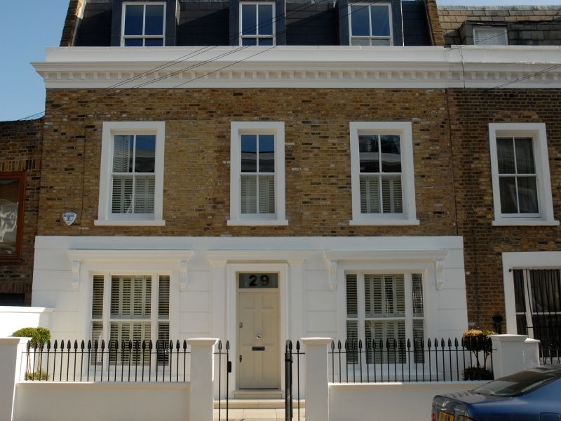 townhouse facing a road with shutters on all windows for increased privacy