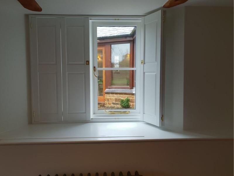 half closed solid shutters on a window in Oxfordshire