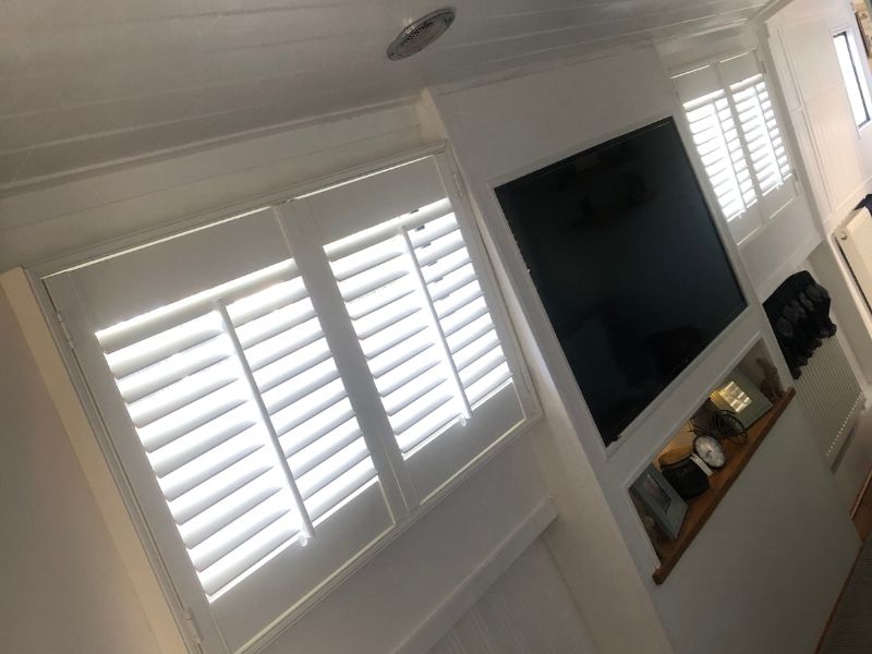 inside a narrowboat with white shutters on the windows