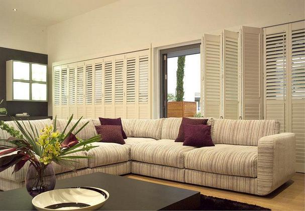 large living room shutters sliding open behind an l shaped modern sofa