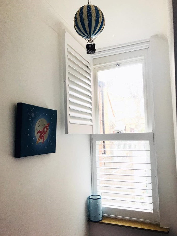 window in a nursery with half open shutters