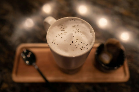 A cup of London Fog latte tea made with Earl Grey tea, along with a spoon and tea bag