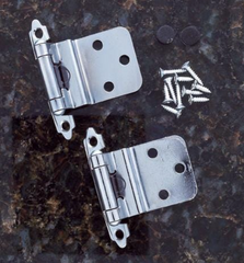 2 chrome self-closing hinges on a black marble surface beside a small pile of screws