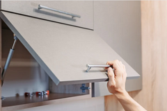 Lift-up hinge on modern gray cabinet.