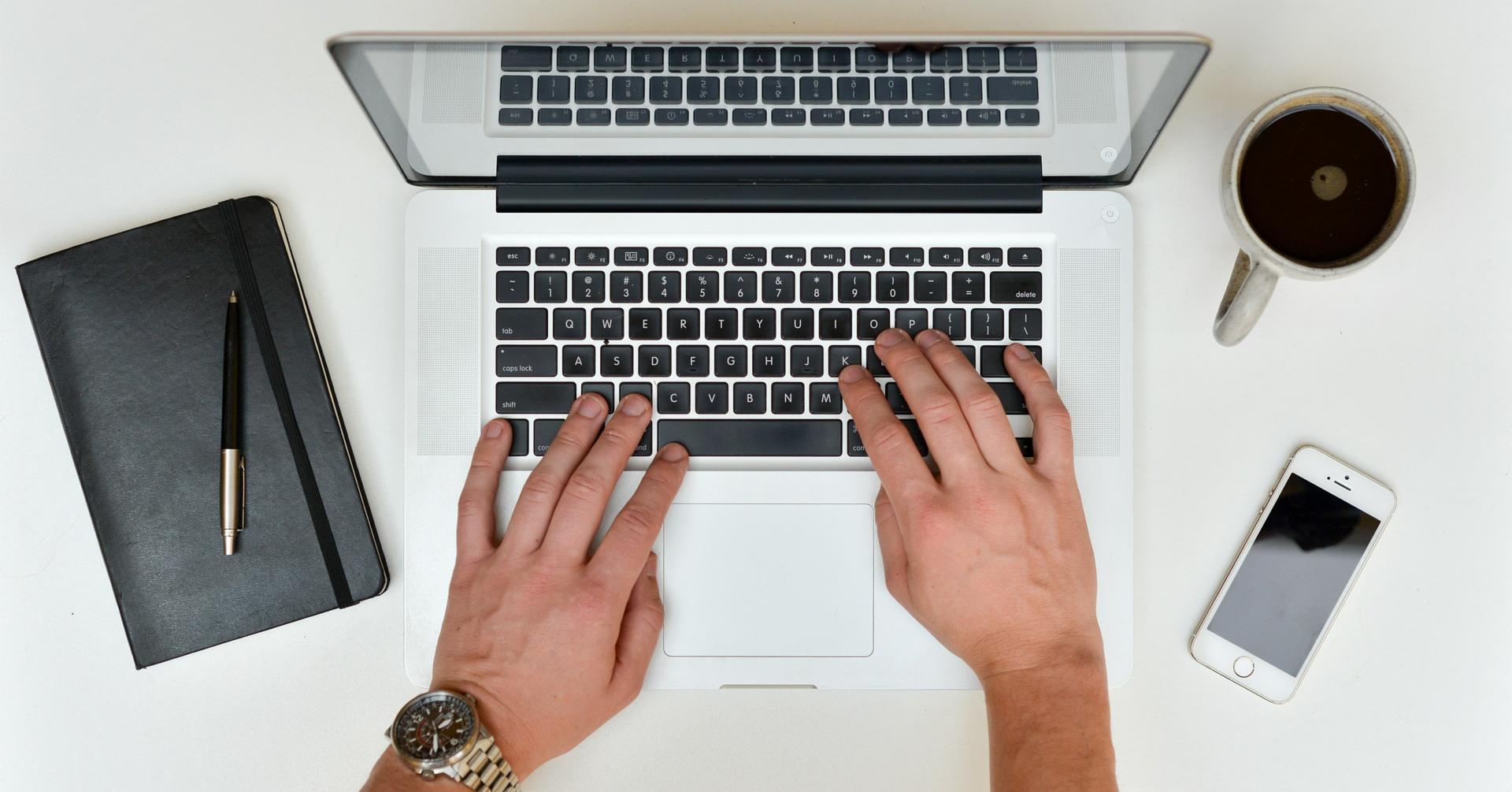 Hands writing a business proposal on a laptop