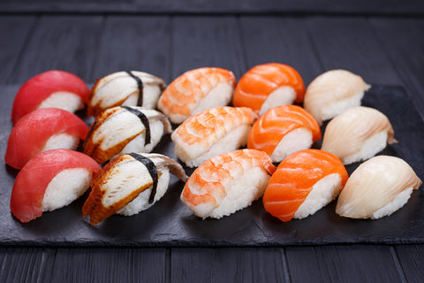 Nigirizushi with salmon, grouper, eel, tuna and prawn, served on black stone slate, available in many sushi restaurants