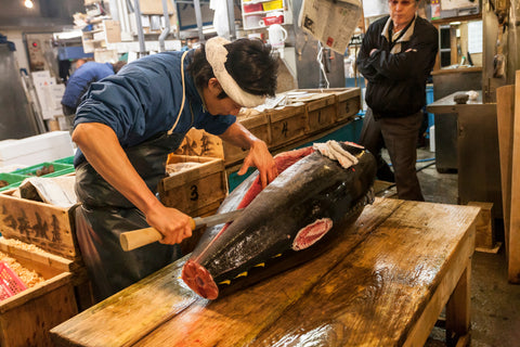 Early morning at Fish Market. Vendor cutting tuna at Tsukiji Fish Market. Freshness for the best sushi