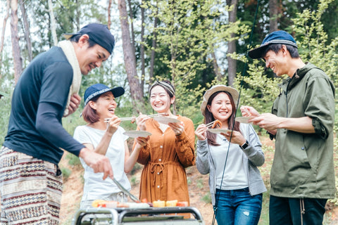 en and women go camping in Japan, having a barbecue in the camp