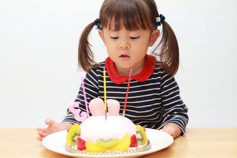 Japanese child blowing out candles.