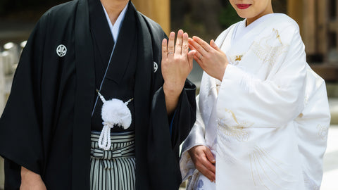 Japanese couple with traditional bride kimono and groom yukata uniform showing wedding rings at wedding party by Closeup shot
