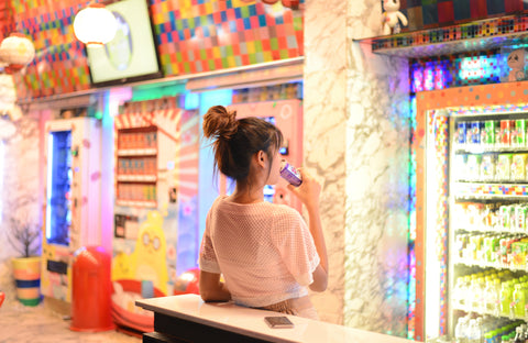 Woman posting in front of Colorful Japanese vending machines