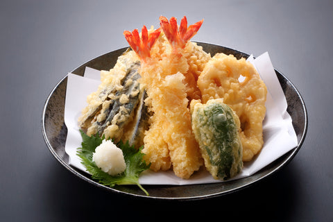 A plate serving a shrimp and vegetable tempura dish.