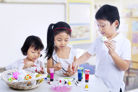 Children are painting easter eggs in art class