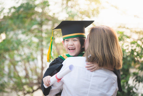 Asian mother embracing her son on graduation day