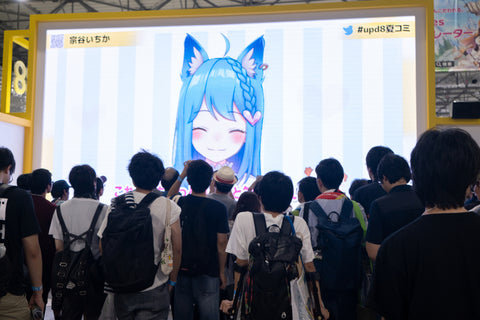 A crowd watches a large screen, during a convention, in Odaiba.