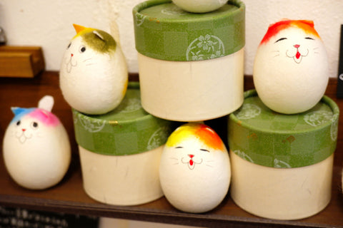 CUTE EGGS PAPER DOLLS ON SHELF NEAR ROUND GIFT BOXES