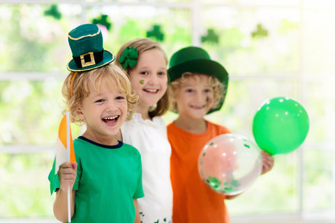 Family celebrating St. Patrick's Day. Irish holiday, culture and tradition. Kids wear green leprechaun hat and beard with Ireland flag and clover leaf.