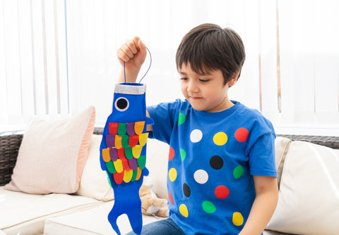 Child boy doing Japanese fish kite in sunny part of many festivals in Japan day summer.