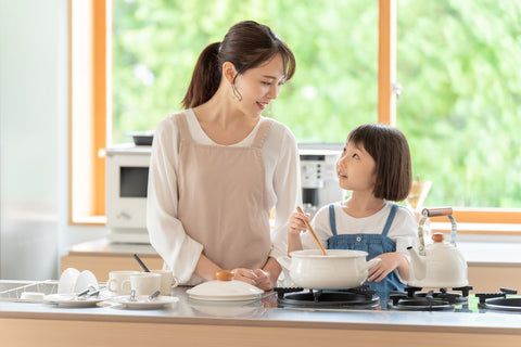 young asian mother and daughter cooking at kitchen