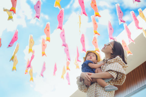 Mother and son watching carp streamer fluttering in the blue sky, Koinobori. One of the largest festivals in Japan