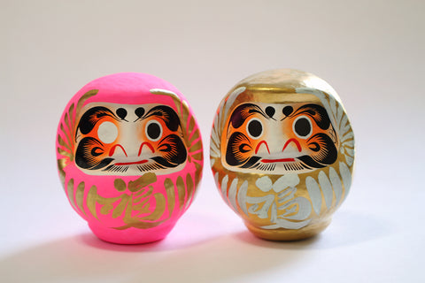 A round traditional Japanese doll "Daruma" with the letters "fortune" printed on the belly