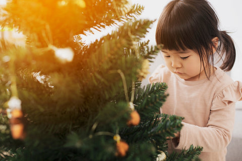 Japanese child decorating a Christmas tree.
