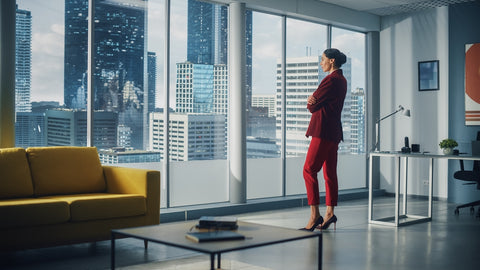 Successful Thoughtful Foreign Woman Wearing Perfect Red Suit Standing in Office Looking out of Window on Big City.