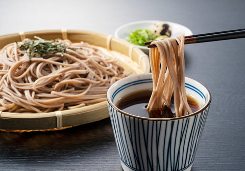 Zaru-soba placed on a black background. Soba noodles dipped in noodle soup. Zaru soba is a traditional Japanese food.