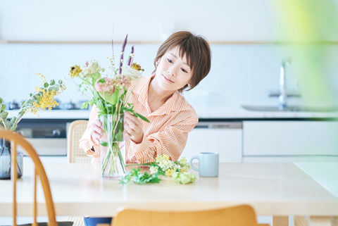 Woman arranging flowers in the room