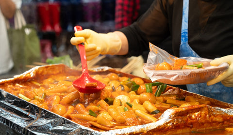 Delicious Korean cuisine Tteokbokki, tasty spicy rice cake with sausages, eggs in market for street food snacks.