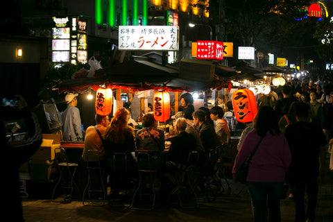 People eating and drinking in a Yatai in Hakata Bay