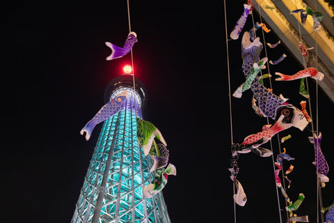 Tokyo Skytree with, colorful carp streamers, Koinobori, a traditional Japanese symbol of boys' celebration, dance in the night sky at night.