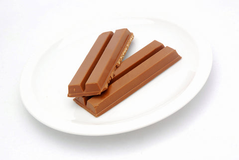 A non-branded chocolate bar that is split in half and laid on a plate.