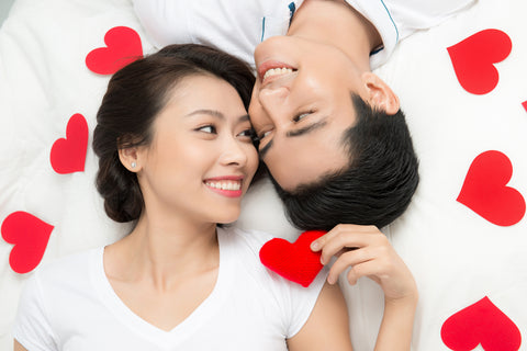 Boyfriend and girlfriend lying taking selfie with happy face expression looking each other in eyes.