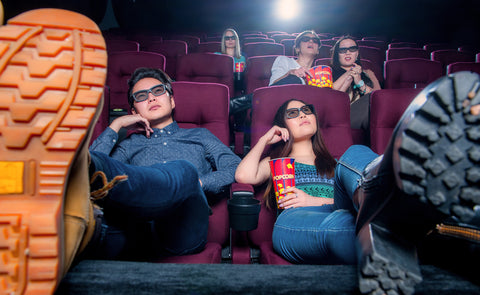 Couple with their feet up at a Japanese movie theater.