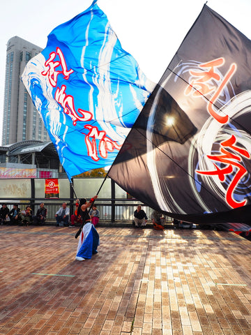 Yosakoi festival on Odaiba. Man waving giant flags.