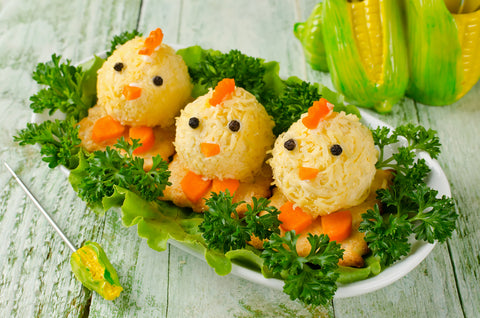 Funny chickens from eggs on the Easter table. Snack of cheese and almonds