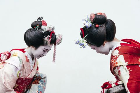 Two geisha walking down the street.