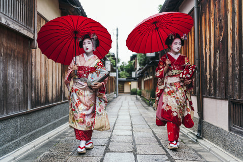 Two geisha walking down the street.