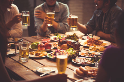 People celebrating the festival they clink glasses beer and dinner happy