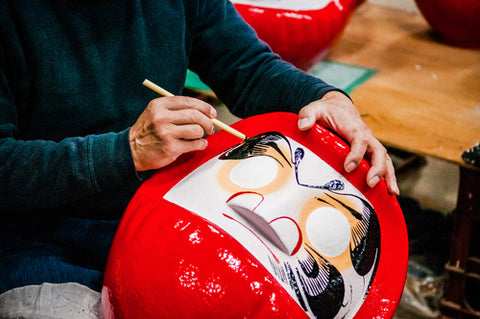 A man making Daruma - Traditional Japanese Culture paper mache doll in Daruma workshop