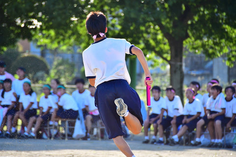 A child running with a baton on Sports Day in Japan