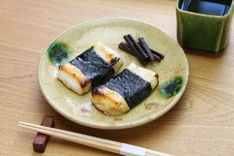 The mochi is grilled in soy sauce, then wrapped in a piece of nori seaweed and eaten