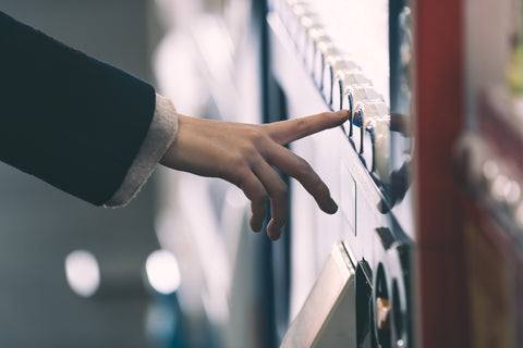 Woman buying with a Japanese vending machine