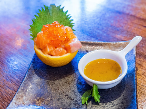 Close up shot of salmon roe and Sashimi with yuzu sauce