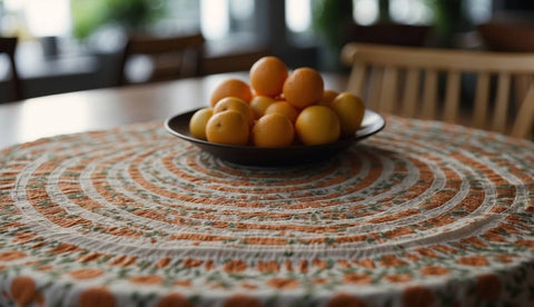 a printed color orange round tablecloth on the table with a plate of orange