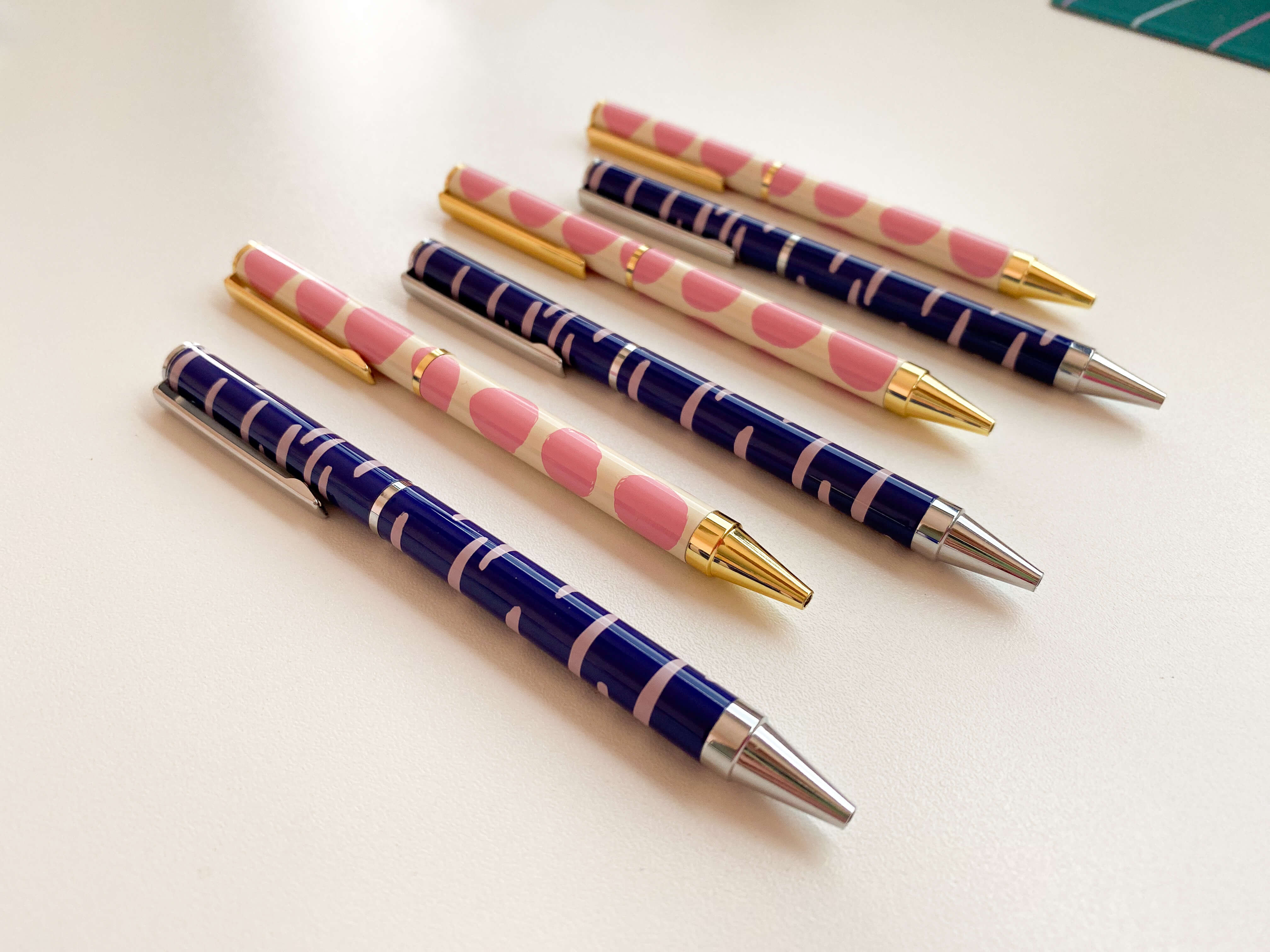 canetas da artista sobre mesa branca